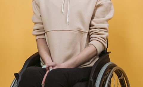 Woman in a Brown Hoodie Jacket Sitting on a Wheelchair